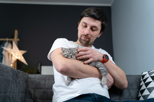 male-owner-holding-cat-in-his-arms